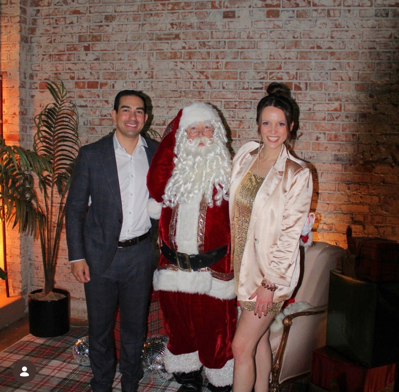 Couple posing with Santa Claus indoors
