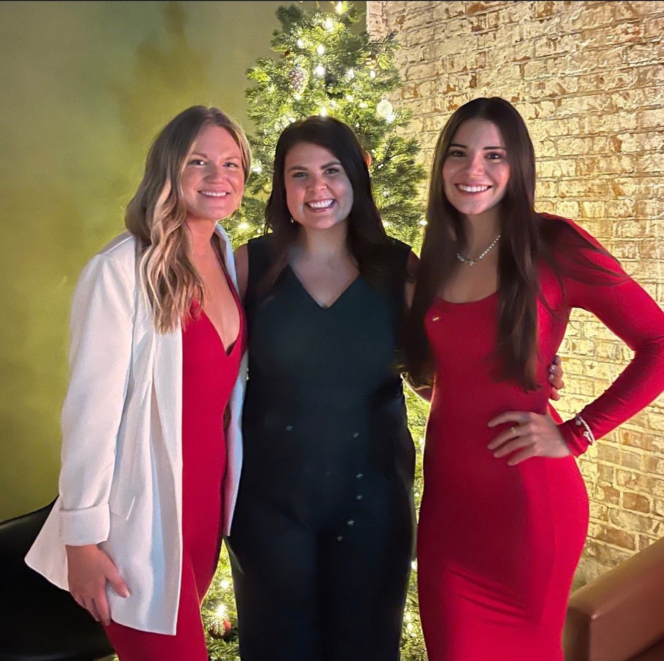 Three women smiling at holiday event