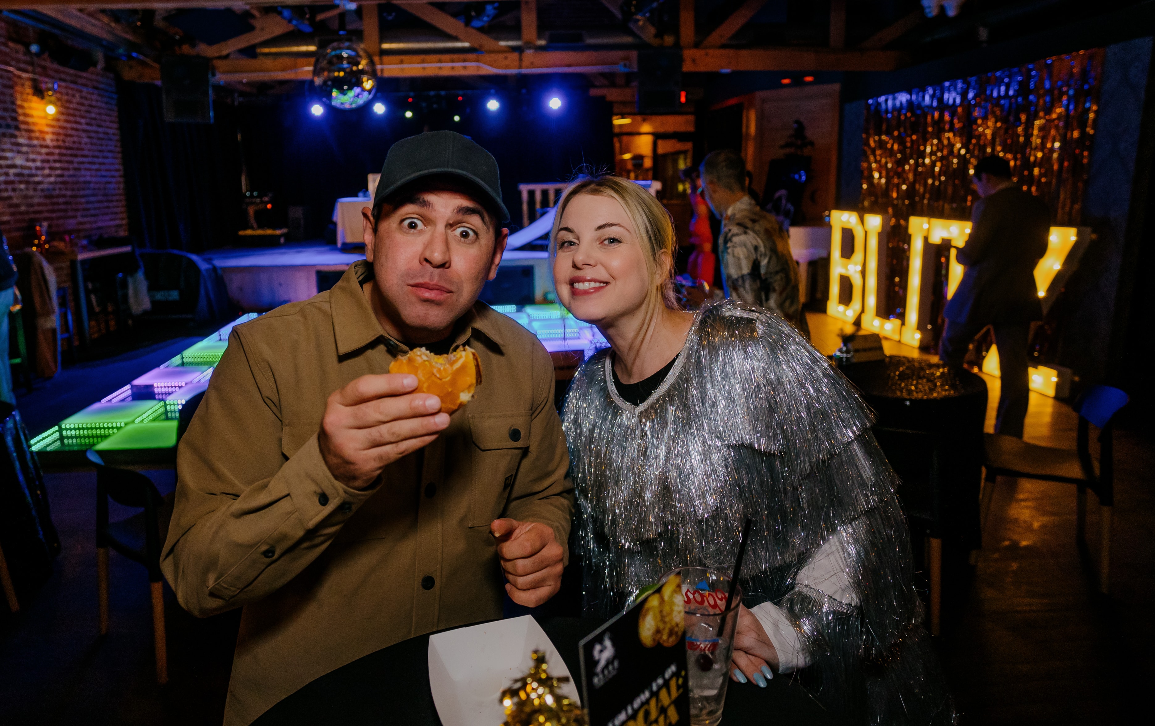 Couple eating pizza at nightclub party