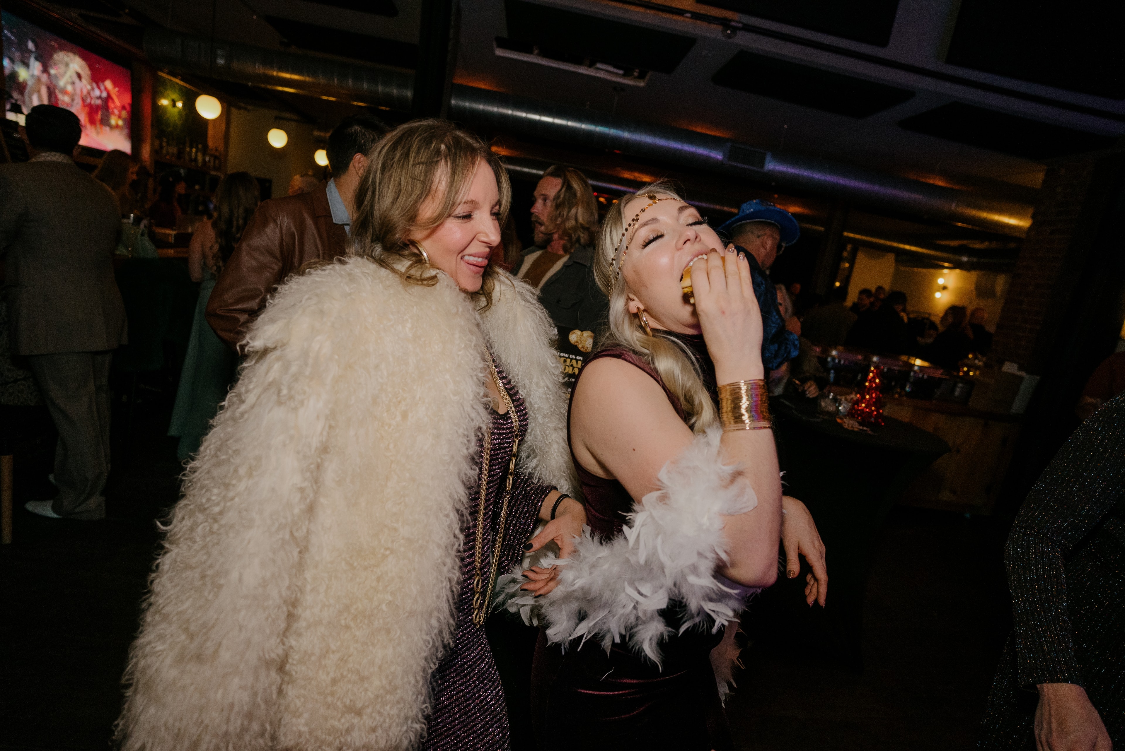 Women in feathered outfits dancing at party