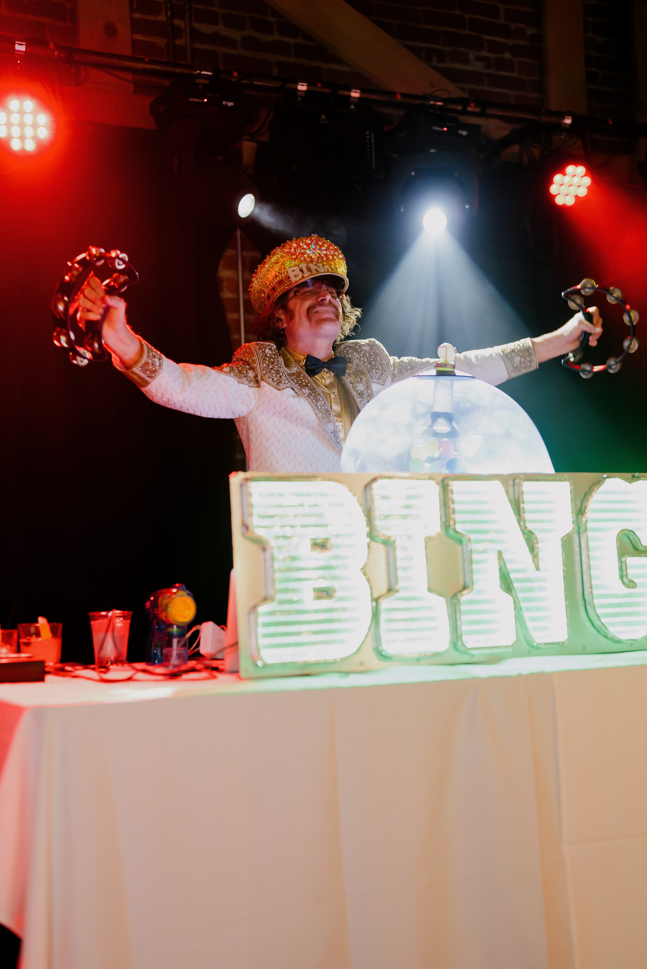 Performer on stage with tambourines raised
