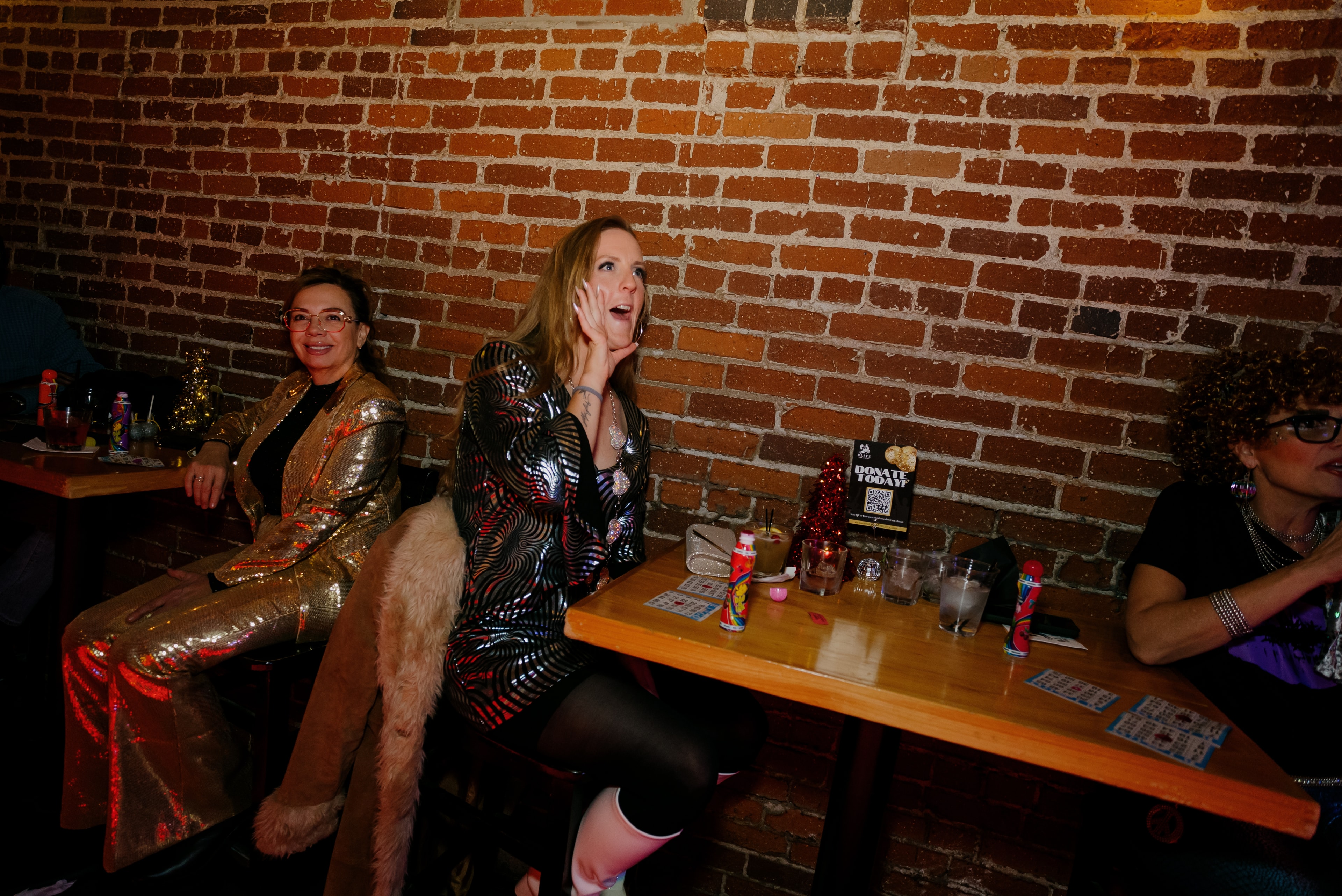 Women in sequined outfits at bar counter