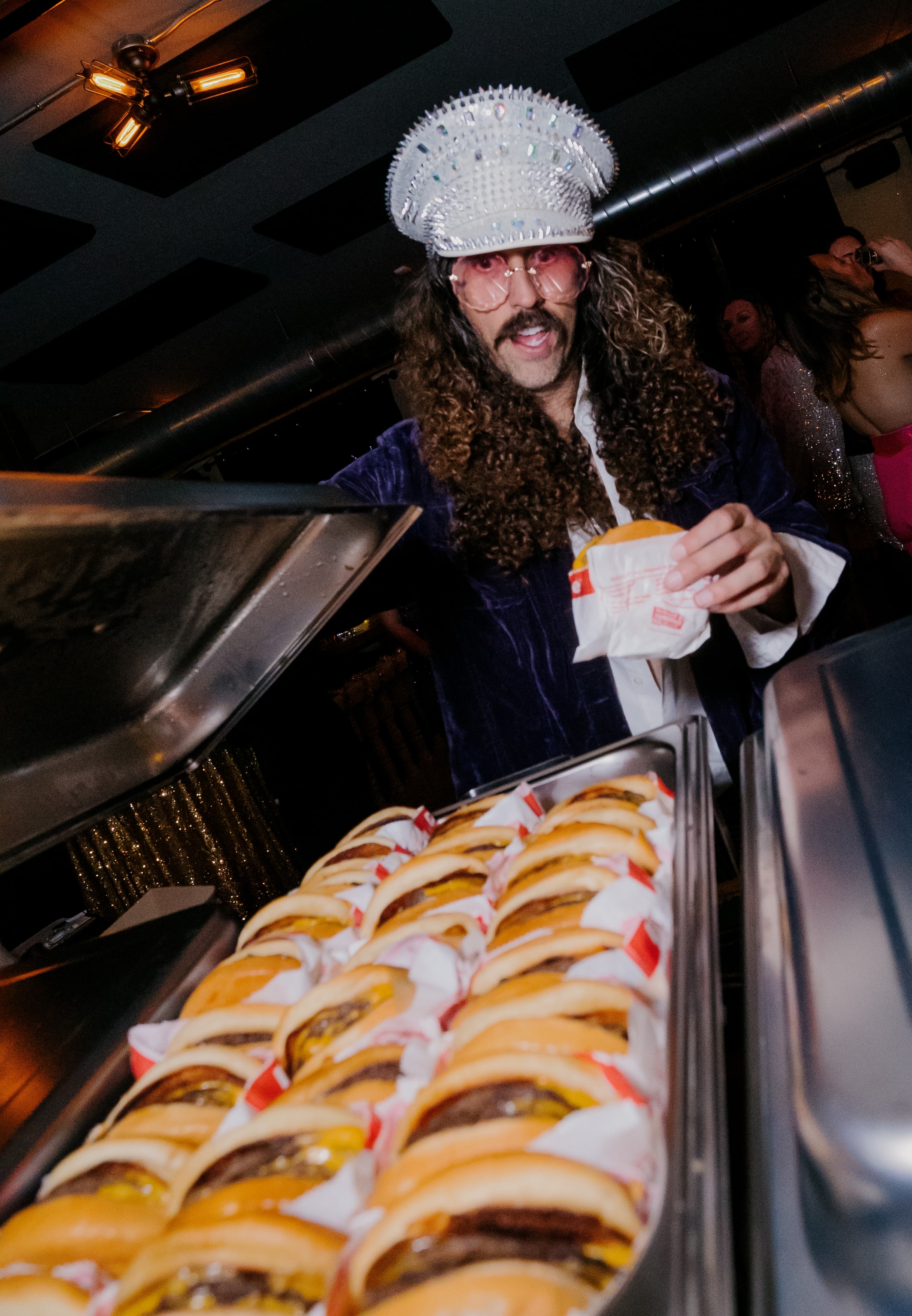 Man in white cap eating hot dog at party